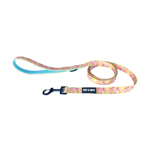 Floral patterned dog leash with black hardware on a white background