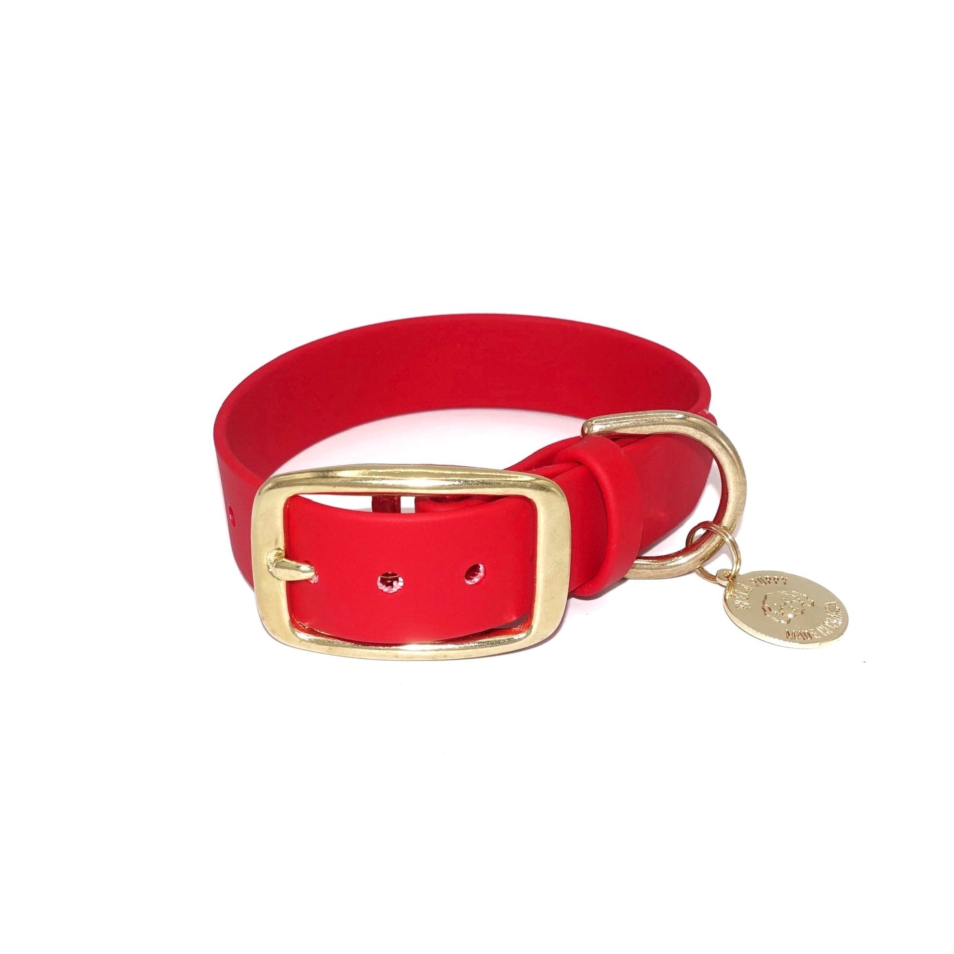 Red dog collar with a gold buckle and tag on a white background