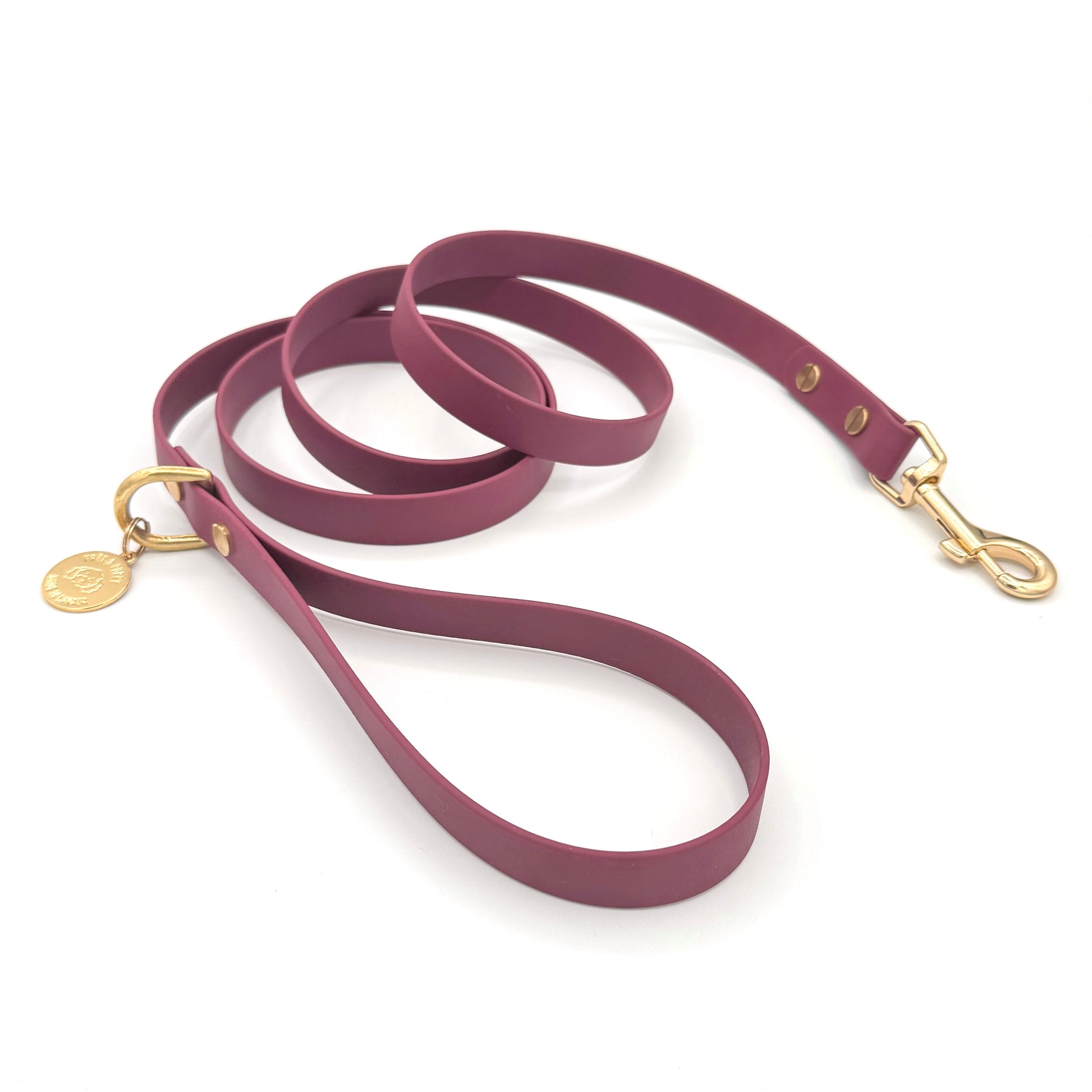 Stylish burgundy dog leash made from high-quality vegan leather, featuring elegant gold hardware. This waterproof leash is soft to the touch, ensuring comfort for pet owners while providing durability for everyday walks. Ideal for pet owners looking for a fashionable, and long-lasting accessory for their dog