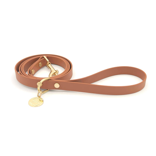 Stylish tan light brown dog leash made from high-quality vegan leather, featuring elegant gold hardware. This waterproof leash is soft to the touch, ensuring comfort for pet owners while providing durability for everyday walks. Ideal for pet owners looking for a fashionable, and long-lasting accessory for their dog