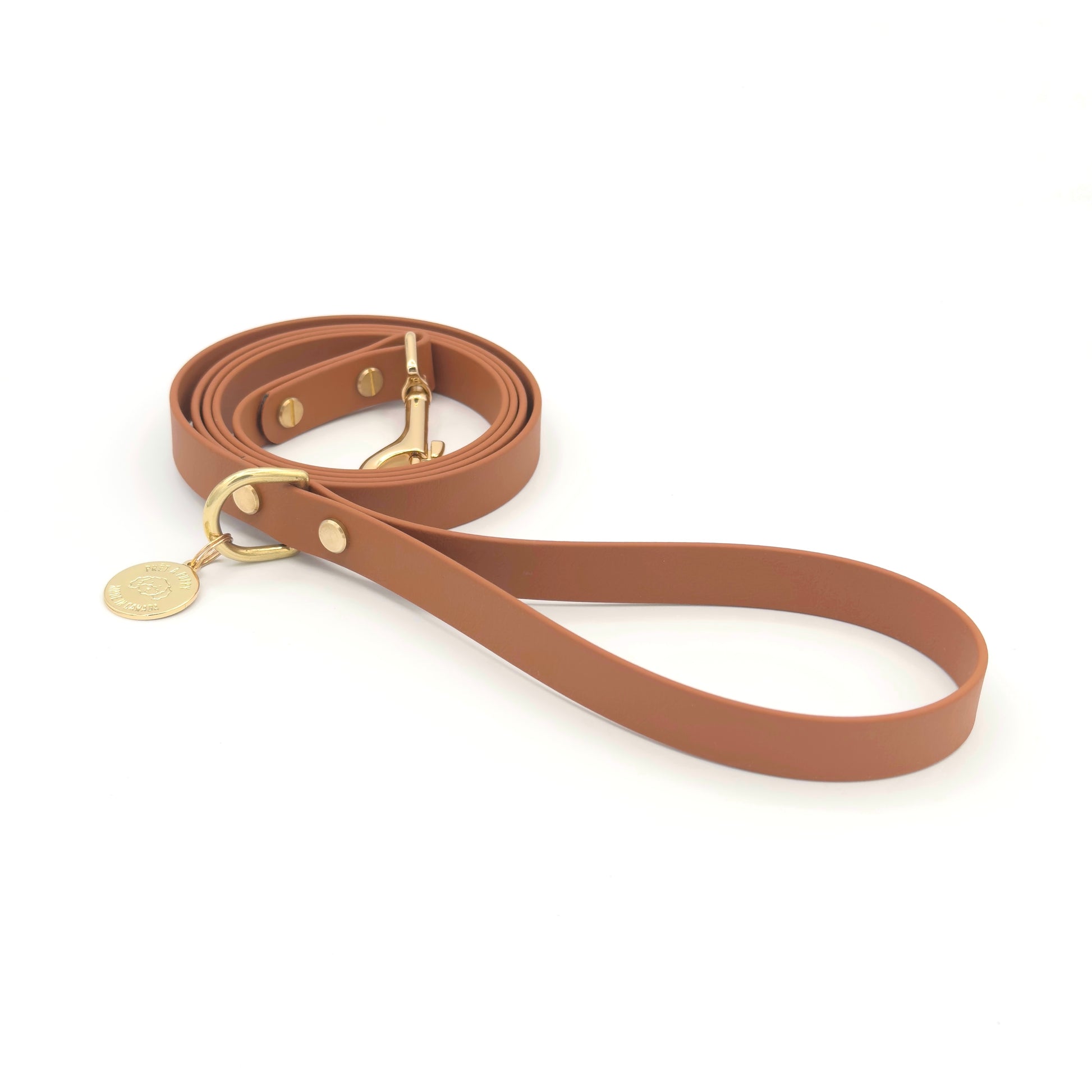 Stylish tan light brown dog leash made from high-quality vegan leather, featuring elegant gold hardware. This waterproof leash is soft to the touch, ensuring comfort for pet owners while providing durability for everyday walks. Ideal for pet owners looking for a fashionable, and long-lasting accessory for their dog